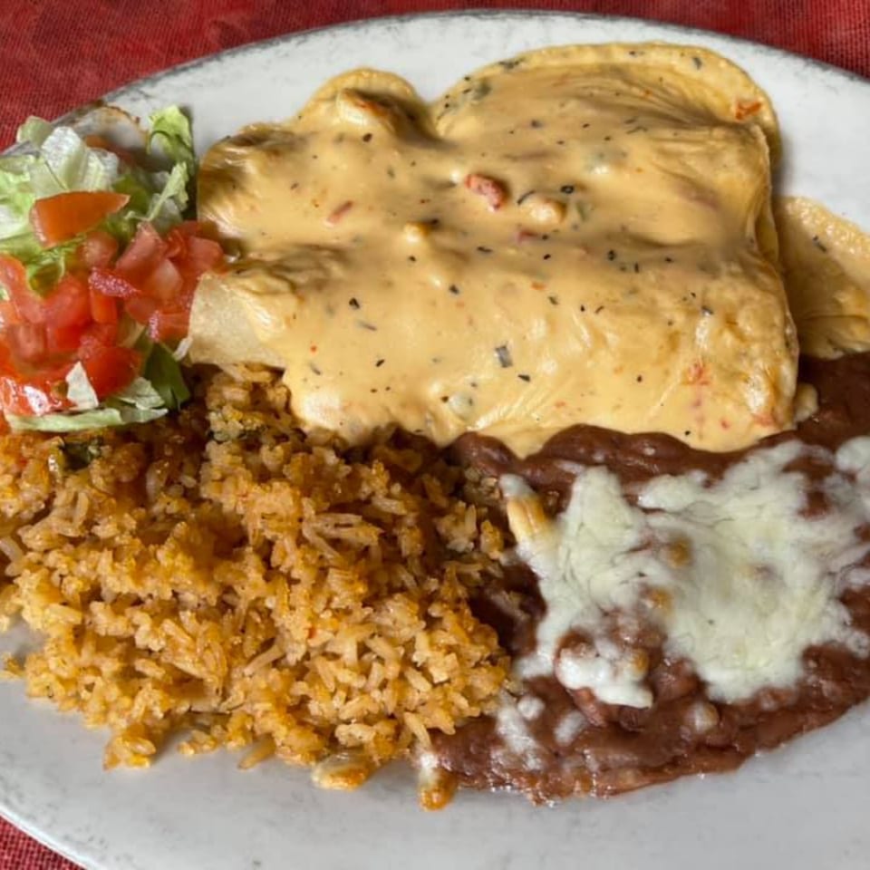 Maria's Mexican Restaurant's enchiladas covered in queso, with rice, refried beans, and a side salad.